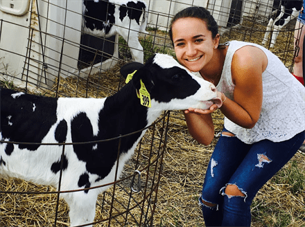 Madeline Davidson with a black and white calf